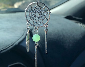 May include: A silver dreamcatcher car charm with green beads and feathers.