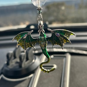 May include: A green and silver dragon car charm with crystal accents hanging from a clear crystal bead.