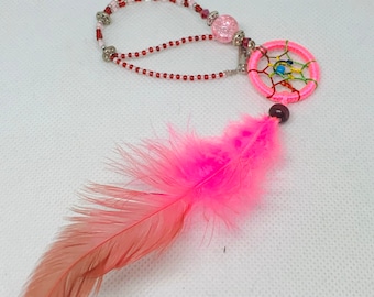 May include: Pink dream catcher necklace with a pink feather, red beads, and a silver chain.