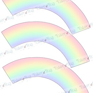 Op de afbeelding: Drie regenboog cupcake-verpakkingen met een verloop van roze, oranje, geel, groen, blauw en paars. De verpakkingen zijn gebogen en klaar om om een cupcake te worden geplaatst.
