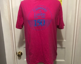 Könnte beinhalten: Ein pinkfarbenes T-Shirt mit einem blauen Kreis-Motiv, auf dem "University of London 1826 - 1986 150 Years" steht.