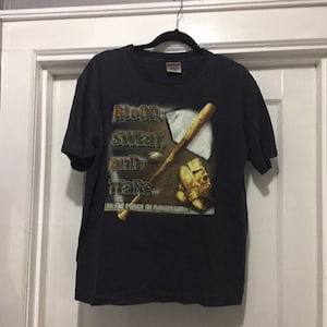 K&ouml;nnte beinhalten: Schwarzes T-Shirt mit einem Grafikdruck eines Baseballschl&auml;gers, Handschuhs und Balls. Der Text "Blood, Sweat, and Tears is the Price of Admission" ist auf dem T-Shirt aufgedruckt.