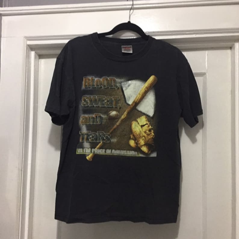 K&ouml;nnte beinhalten: Schwarzes T-Shirt mit einem Grafikdruck eines Baseballschl&auml;gers, Handschuhs und Balls. Der Text "Blood, Sweat, and Tears is the Price of Admission" ist auf dem T-Shirt aufgedruckt.