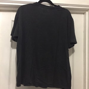 K&ouml;nnte beinhalten: Schwarzes T-Shirt mit Rundhalsausschnitt und kurzen &Auml;rmeln.