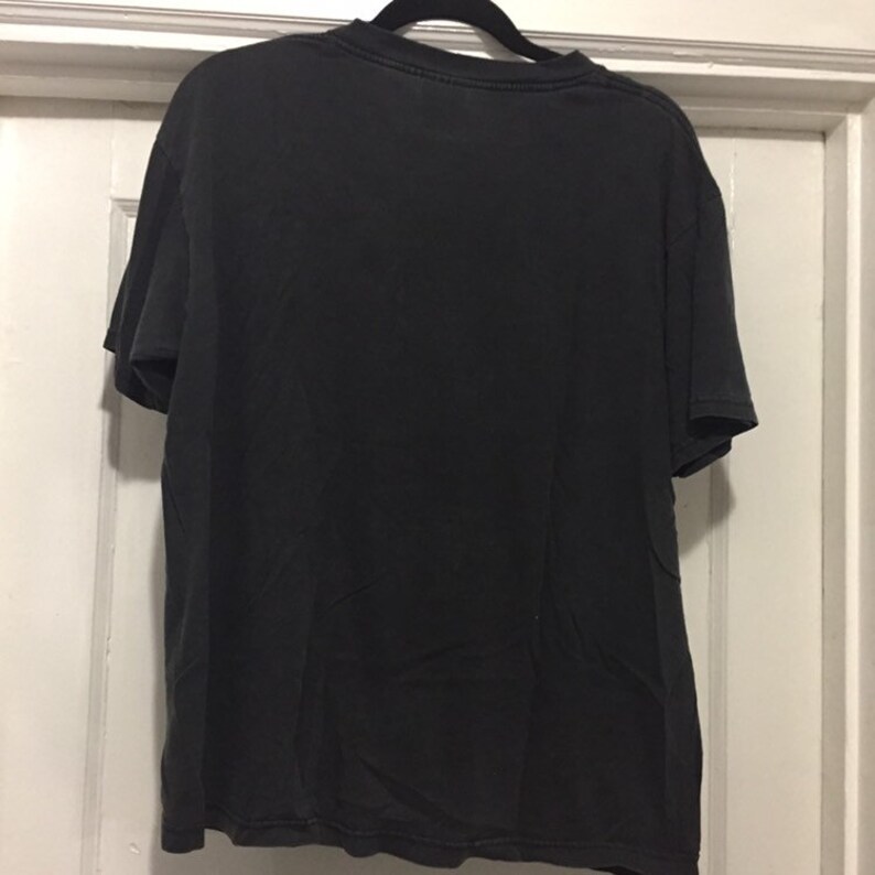 K&ouml;nnte beinhalten: Schwarzes T-Shirt mit Rundhalsausschnitt und kurzen &Auml;rmeln.
