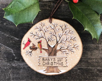 Baby's first Christmas wood slice ornament. Personalized wooden sign on snowy tree with cardinal family. Handmade by Forage Workshop