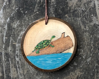 Painted turtle sitting on a log wood slice ornament. Handmade by Forage Workshop PREORDER