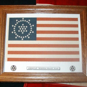 May include: A framed print of the "Whipple Peace" flag, a historical American flag design with 36 stars arranged in a circle. The flag is displayed on a red, white, and blue background.