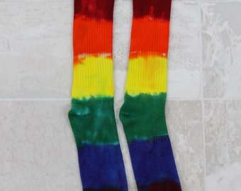 May include: A pair of rainbow tie-dye socks with red, orange, yellow, green, blue, and purple stripes.