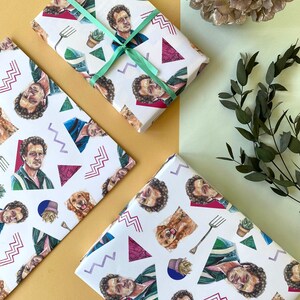 May include: White wrapping paper with a repeating pattern of a man's portrait, a golden retriever, a gardening fork, and geometric shapes. A gift is wrapped with a light green ribbon. The background is a mix of yellow and light green.