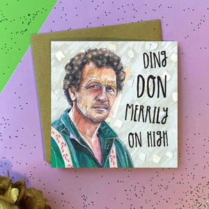 May include: A greeting card featuring a cartoon illustration of a man with brown hair and a green shirt. The text on the card reads "Ding Don Merrily On High".