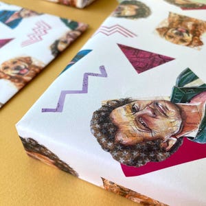 May include: White wrapping paper with a repeating pattern of a person's face and a dog's face, along with purple zigzags and pink triangles. The wrapping paper is used to wrap gifts.