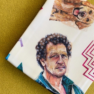 May include: A white canvas featuring a portrait of a man with curly hair and a dog. The man is wearing a blue shirt. The dog is brown and lying down. Geometric shapes and patterns are also visible.