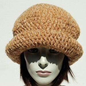 Puede incluir: Un gorro de punto marr&oacute;n y blanco con un ala ancha.
