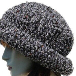 Puede incluir: Un gorro gris de punto con un ala ancha. El gorro est&aacute; hecho de un hilo grueso y texturizado.