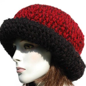 Puede incluir: Un gorro de punto rojo y negro con un ala ancha. El gorro est&aacute; hecho de un hilo suave y peludo.