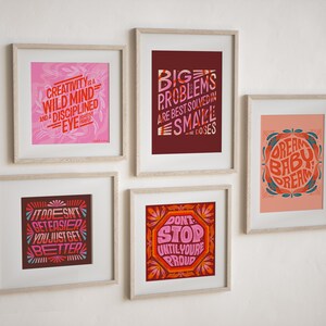 May include: Five framed prints with motivational quotes in a variety of colors and fonts. The quotes are: "Creativity is a wild mind and a disciplined eye", "Big problems are best solved in small doses", "It doesn't get easier, you just get better", "Don't stop until you're proud", and "Dream baby dream".