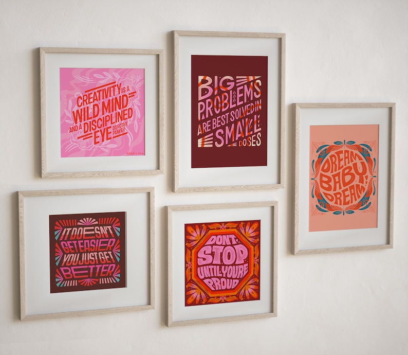 May include: Five framed prints with motivational quotes in a variety of colors and fonts. The quotes are: "Creativity is a wild mind and a disciplined eye", "Big problems are best solved in small doses", "It doesn't get easier, you just get better", "Don't stop until you're proud", and "Dream baby dream".