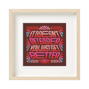 May include: Framed print with a motivational quote in a colorful, retro style. The quote reads "It doesn't get easier, you just get better".