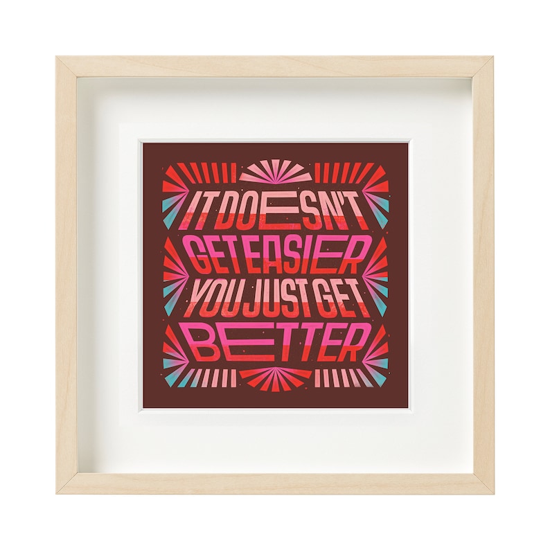 May include: Framed print with a motivational quote in a colorful, retro style. The quote reads "It doesn't get easier, you just get better".