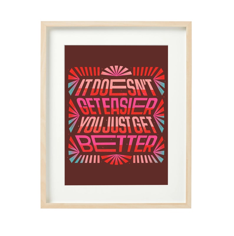 May include: Framed motivational poster with a red, pink, and blue color scheme. The poster features the text "It doesn't get easier, you just get better."