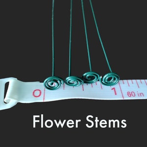 May include: Five green wire flower stems with a spiral at the end, measured against a white tape measure with red markings. The tape measure reads "60 in" and "1". The text "Flower Stems" is written below the image.