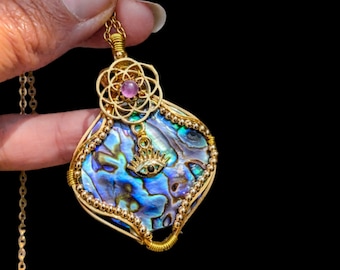 Abalone mother-of-pearl pendant with seed of life and amethyst with a golden eye