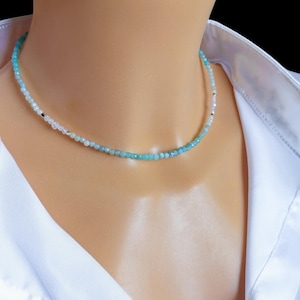 Peut inclure: Un collier ras de cou délicat avec un dégradé de perles bleu clair et bleu foncé. Le collier est composé de petites perles rondes et est parfait pour ajouter une touche d'élégance à n'importe quelle tenue.