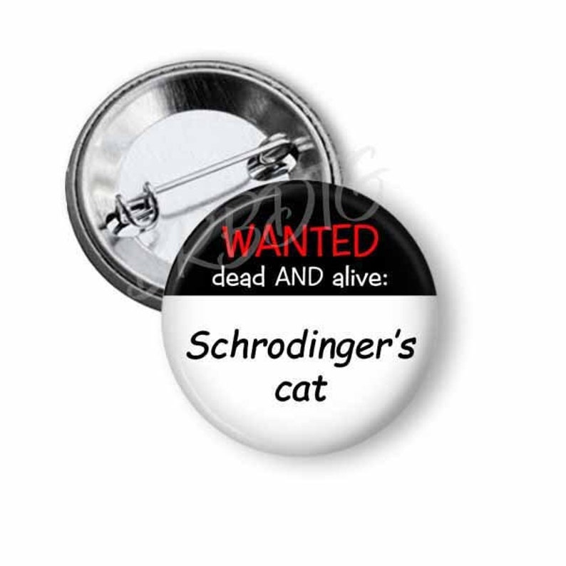 Peut inclure: Un bouton noir et blanc avec le texte "WANTED dead AND alive: Schrodinger's cat" en lettres rouges et noires.