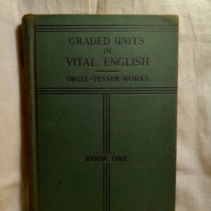 May include: A green book titled "Graded Units in Vital English" by Orgel-Peyser-Works. The book is labeled "Book One" and has a textured cover.