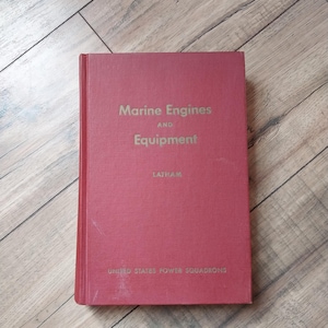 May include: A red hardcover book titled "Marine Engines and Equipment" by Latham, published by United States Power Squadrons.