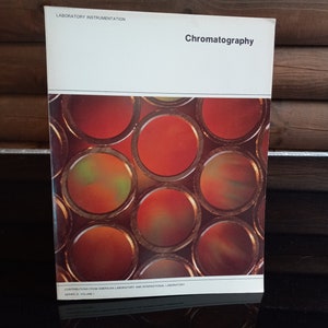 May include: A book titled "Chromatography" with a cover image of a series of red, orange, and green circles. The book is part of the "Laboratory Instrumentation" series and is a "Contribution from American Laboratory and International Laboratory".
