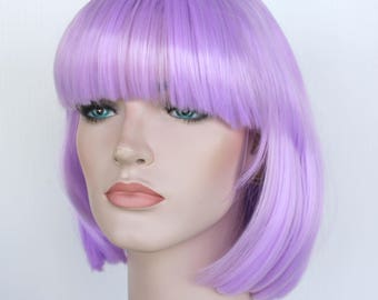 May include: A short, straight, lavender wig with blunt bangs. The wig is styled in a bob shape and has a smooth, shiny finish.