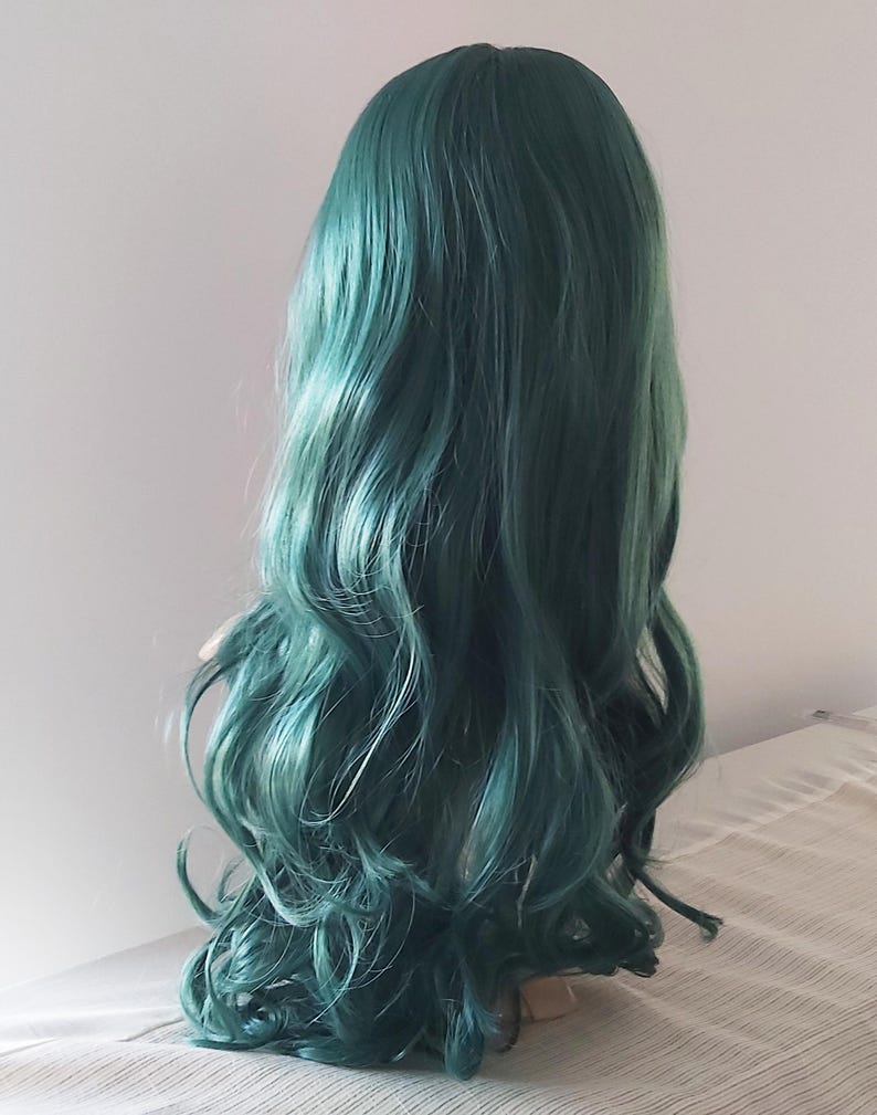 May include: A long, wavy, teal green wig on a mannequin head.