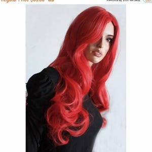 Puede incluir: Una peluca larga de color rojo brillante con ondas sueltas. La peluca est&aacute; peinada con raya lateral y cae hasta los hombros.