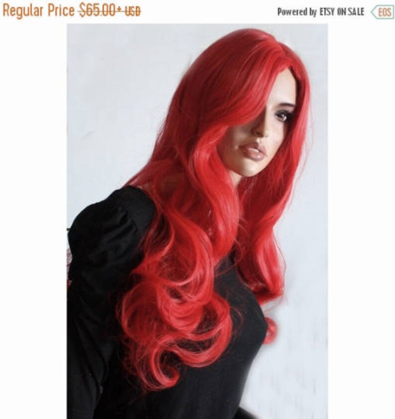 Puede incluir: Una peluca larga de color rojo brillante con ondas sueltas. La peluca est&aacute; peinada con raya lateral y cae hasta los hombros.