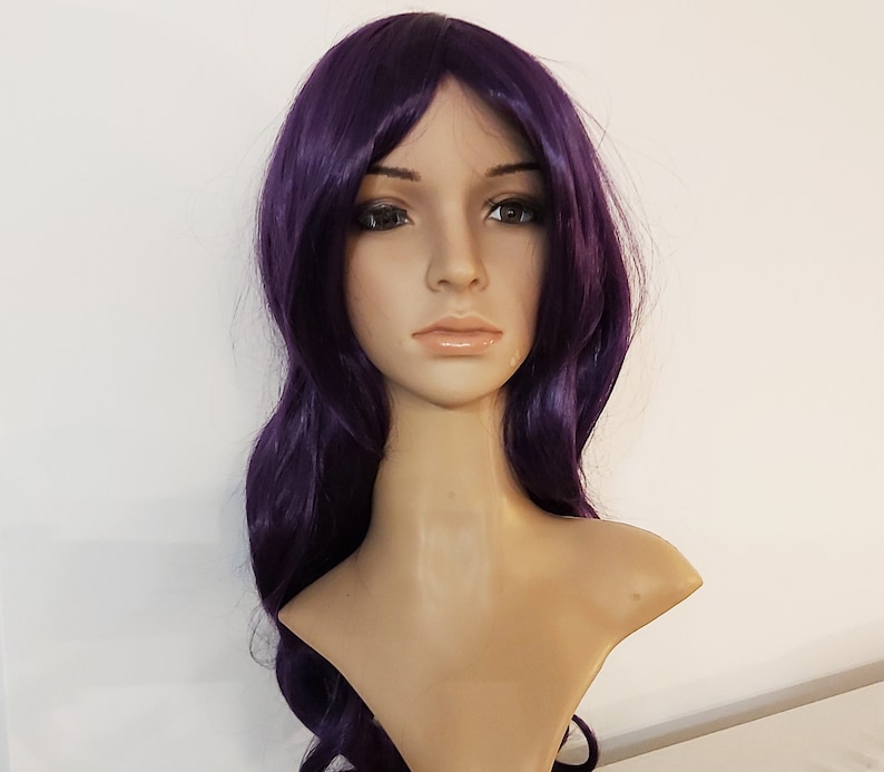 May include: A long, wavy purple wig with a side part. The wig is styled in loose waves and falls to the shoulders.