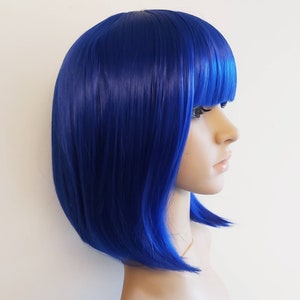 May include: A short, straight, blue wig with bangs. The wig is made of synthetic hair and is styled in a bob.