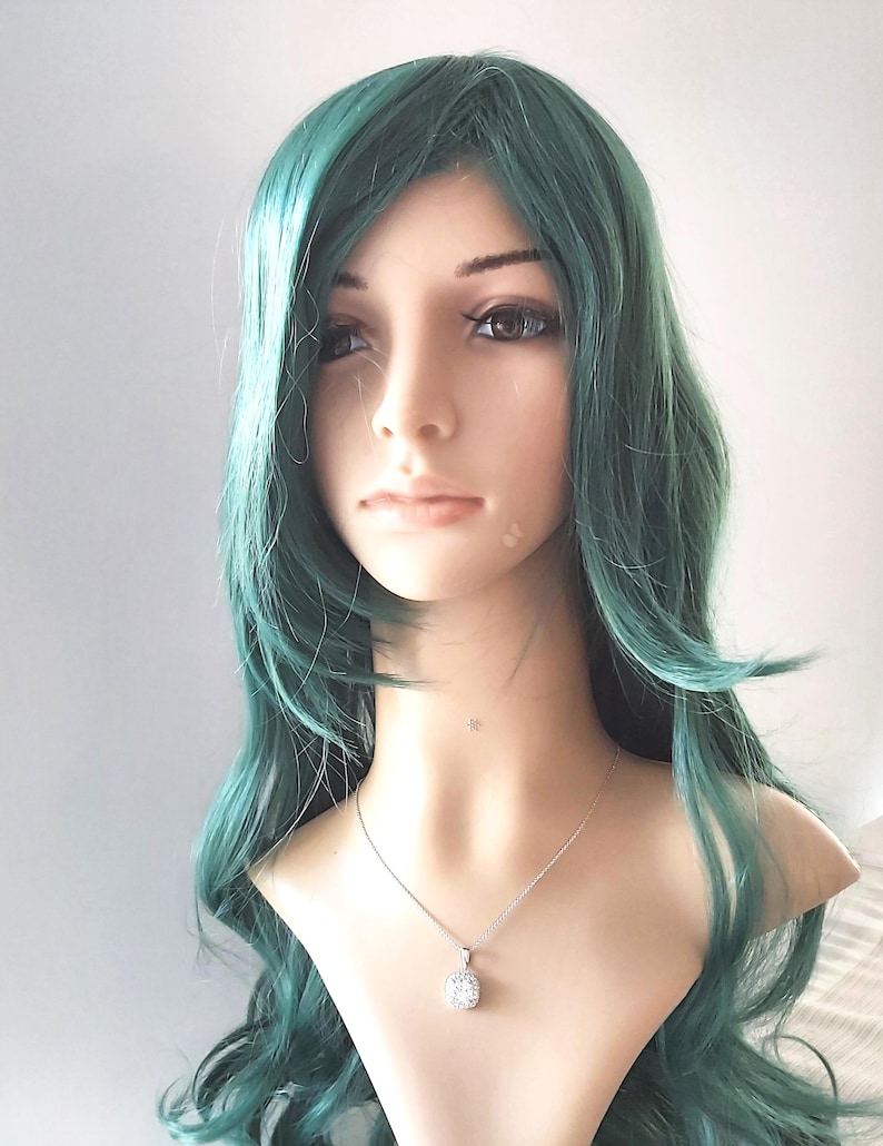 A teal green wavy long wig for women. The wig has a side part and is styled in loose waves.