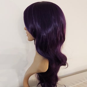 May include: A long, wavy, dark purple wig with a side part. The wig is styled with loose waves and falls to the shoulders.