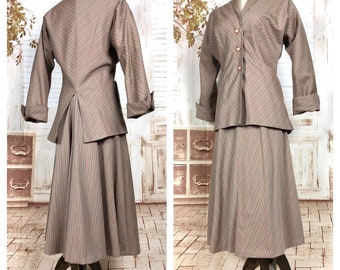 May include: A vintage two-piece suit in a taupe and red striped pattern. The suit includes a long-sleeved jacket with a notched collar and a flared skirt. The jacket has three buttons and the sleeves are cuffed. The skirt falls to mid-calf.