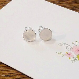 Peut inclure: Une paire de boucles d'oreilles en argent avec des pierres rondes, blanches et opaques.