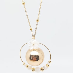 Pu&ograve; includere: Una collana d'oro con un grande ciondolo a forma di sfera dorata circondato da un cerchio di perle bianche e un ciondolo a forma di fiore bianco.