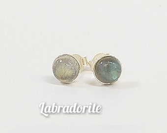 May include: A pair of silver stud earrings featuring round labradorite gemstones. The stones display an iridescent blue-green colour.