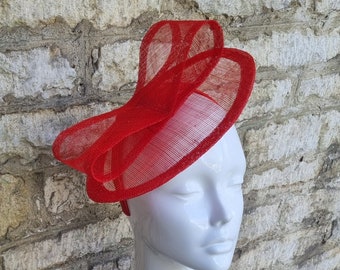 Red fascinator hat for weddings or church in bright red oval shape with bow decoration on headband