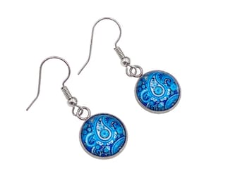 May include: A pair of dangle earrings with a round, blue paisley design. The earrings have silver-colored hooks and circular pendants. The paisley pattern features shades of blue and white, creating a detailed and eye-catching design.