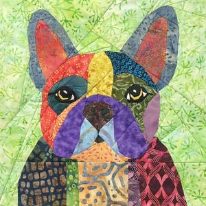 May include: A patchwork quilt depicting a French Bulldog's face. The dog's face is made from various fabrics in shades of red, blue, yellow, and purple. The background is a light green with a leaf pattern.