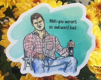 Può includere: Un adesivo con un'illustrazione ad acquerello di un uomo con una camicia a quadri rossa e jeans blu, seduto e con in mano una bottiglia di birra. Il testo "Wish you weren't so awkward bud" è incluso.