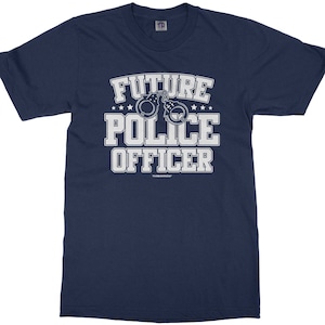 May include: A navy blue t-shirt with the text "Future Police Officer" in white lettering. The text is surrounded by stars and a graphic of handcuffs.