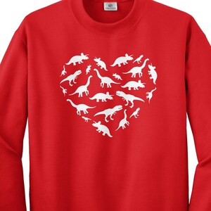 May include: Red sweatshirt with a white heart-shaped design featuring multiple dinosaur silhouettes.